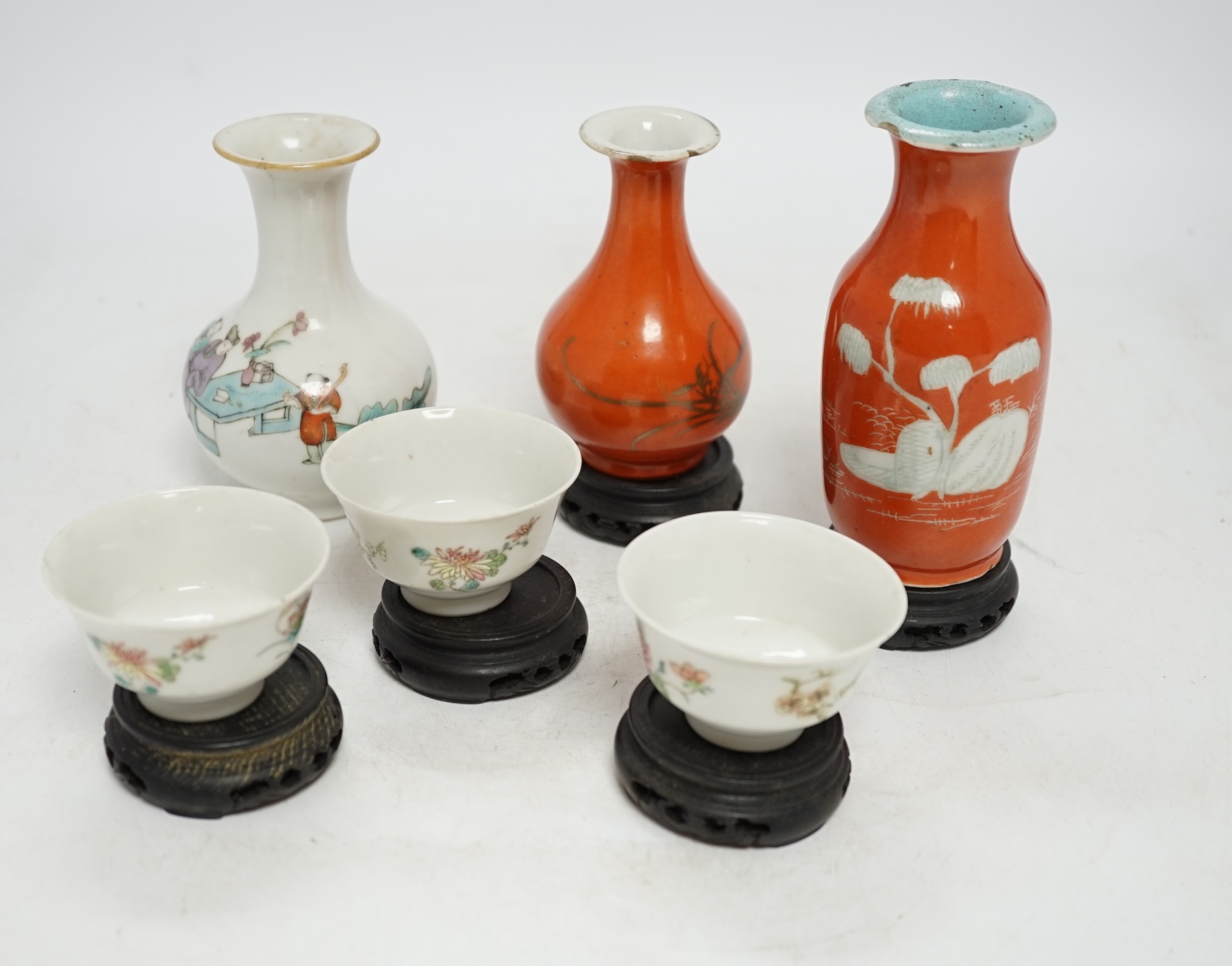 Six Chinese miniature porcelain vases and tea bowls, with wood stands, largest overall 15cm high. Condition - poor to fair